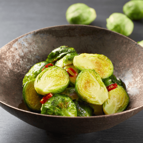 Roasted Brussels sprouts served on a plate, showcasing their crispy texture and vibrant color.