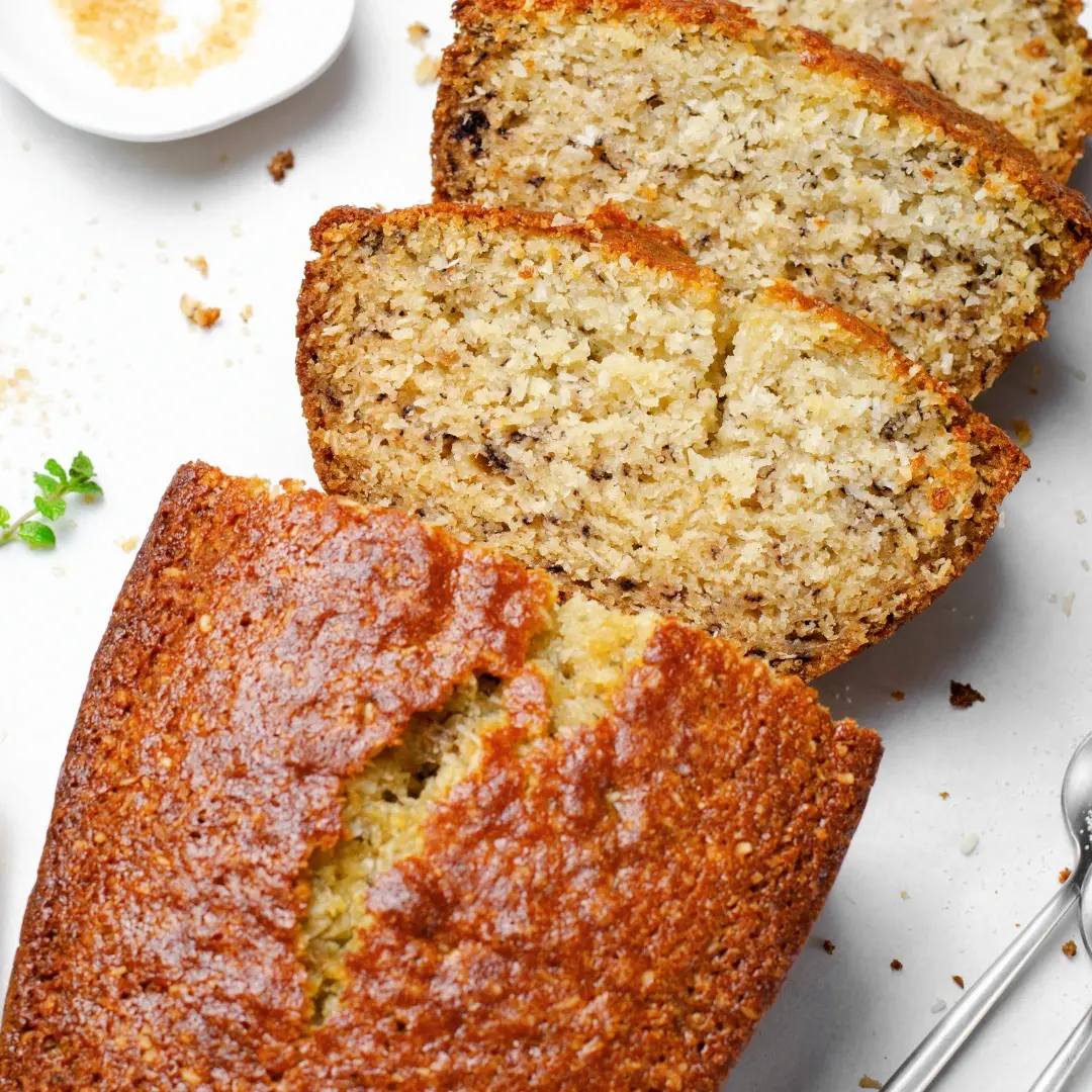 A slice of moist banana bread made with cake mix, topped with banana slices and walnuts.